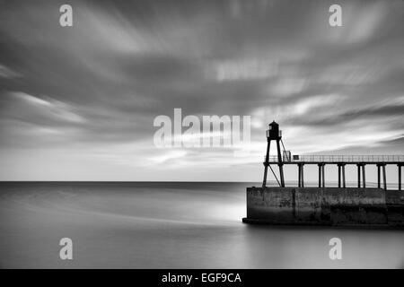 Sunrise over the east pier at Whitby on the Yorkshire coastline. Stock Photo