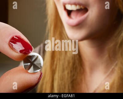 The symbol photo 'medicine' shows a young woman in taking a tablet |. Stock Photo