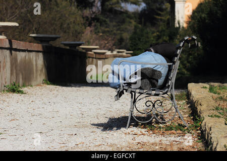 man sleeping on a park bench Stock Photo