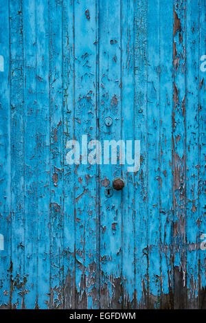 Old painted blue wooden door with peeling paint texture Stock Photo