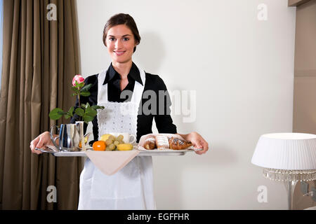 Happy Maid Carrying Breakfast Tray Stock Photo