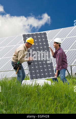 Technicians installing solar panels Stock Photo