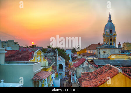 View over the rooftops of the old city of Cartagena during a vibrant sunset. The spire of Cartagena Cathedral stands tall and pr Stock Photo