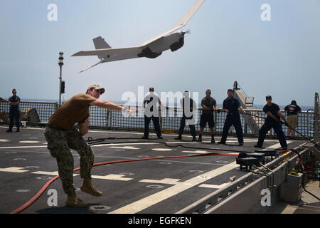 A US Navy sailor launches a RQ-20A  Aqua Puma aerial drone from aboard the Military Sealift Command’s joint high-speed vessel USNS Spearhead February 10, 2015 off the coast of Ghana in the Atlantic Ocean. Stock Photo