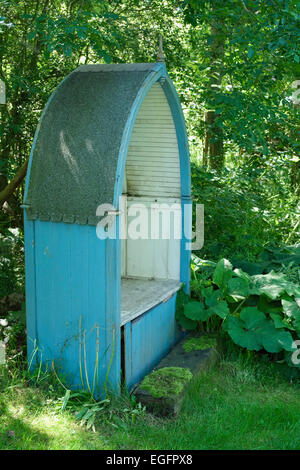 Covered Wooden Garden Seat in the Shape of a Boat Stock Photo