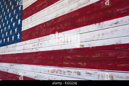 An American or United States flag painted on a wooden plank wall in red, white and blue. Stock Photo