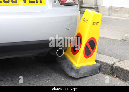 Car badly parked against a Police No Parking cone Stock Photo