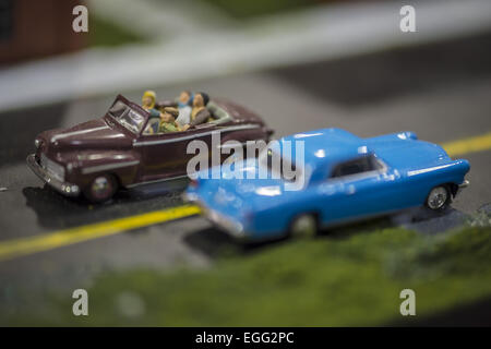 Hicksville, New York, USA. 22nd Feb, 2015. A blue classic model car and brown model car with driver and passengers are in road scene display at the Model Train Exhibit is hosted by Trainville Hobby Depot at the Broadway Mall. Donations were accepted at exhibit to support the Nassau County Empire State Games for the Physically Challenged. © Ann Parry/ZUMA Wire/Alamy Live News Stock Photo