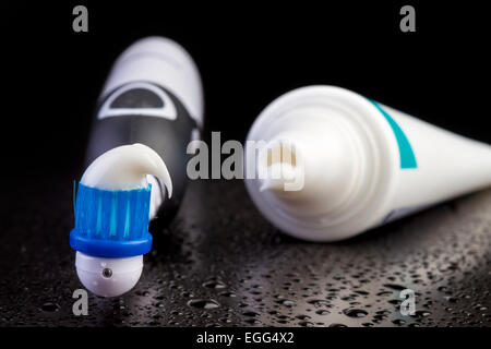 Black toothbrush with toothpaste on black background Stock Photo