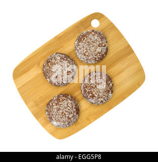 Top view of several glazed gingerbread cookies on a wood cutting board atop a white background. Stock Photo