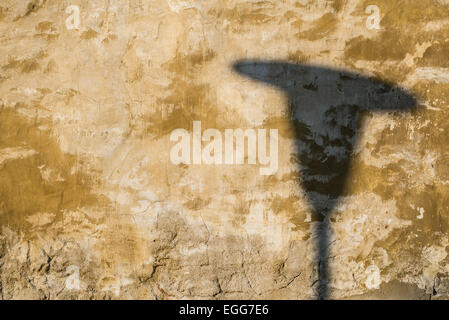 Shadow of street lamp on old yellow painted wall Stock Photo