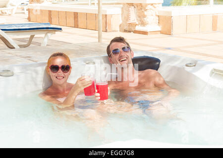Smiling loving couple relaxing together on a jacuzzi pool at tourist resort Stock Photo