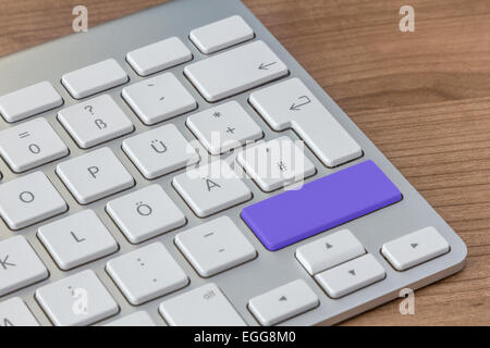 Large blue button of a modern keyboard on a wooden desktop Stock Photo