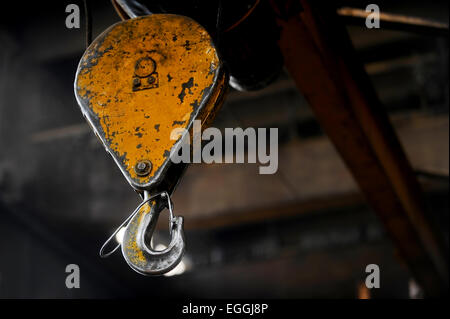 Industrial metal yellow hook detail shot inside a factory Stock Photo