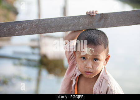 Young boy with thanaka,cosmetic paste on his face at village on bank of Inle Lake,Burma,Myanmar, Stock Photo