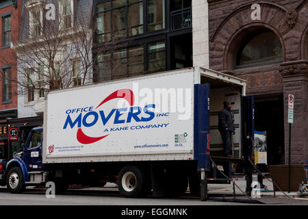 Office moving service workers move large furniture on dollies - USA Stock Photo