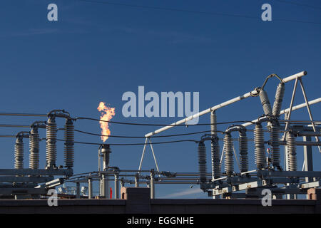 Denver, Colorado - A flare burns off gas at near electrical equipment at Suncor Energy's oil refinery. Stock Photo