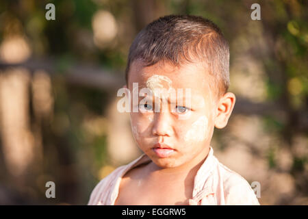 Young boy with thanaka,cosmetic paste on his face at village on bank of Inle Lake,Burma,Myanmar, Stock Photo