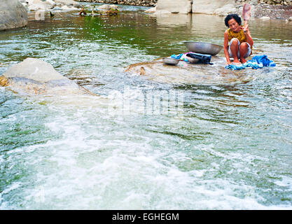 Philippines woman washing clothes on the river in traditinional way. More than one-quarte Stock Photo