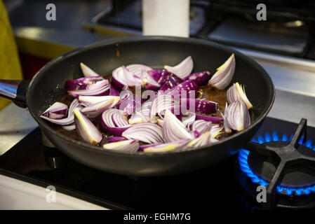 Preparing steak sauce from red onion wedges, caramel and red wine Stock Photo