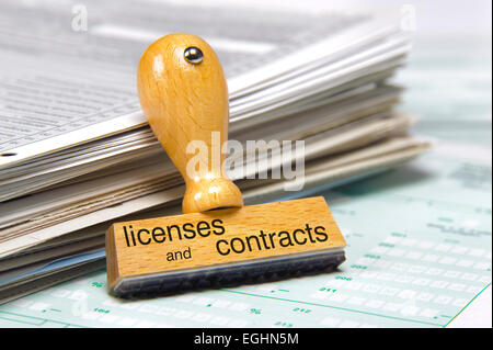 licenses and contracts printed on rubber stamp over documents Stock Photo