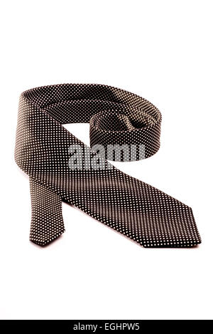 A black tie with white dots rolled out on a white isolated background. Stock Photo