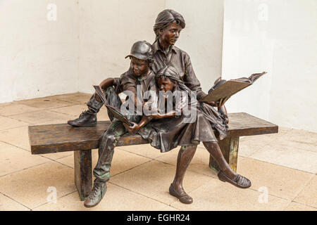 The 'Joy of Reading' is located at Hamilton City Hall and Arts Centre, Bermuda  is a  bronze sculpture by artist George Lundeen. Stock Photo