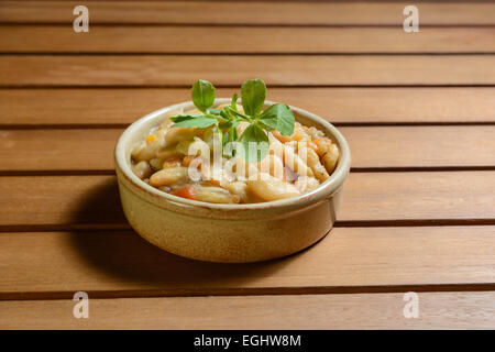 Spicy Spanish bean stew with vegetables in a brown terra cotta bowl. Fabada Asturiana. Stock Photo