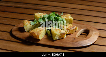 Spanish omelette. Traditional Spanish dish consisting of an egg omelette with added potatoes, red onoions and fried in veg oil. Stock Photo