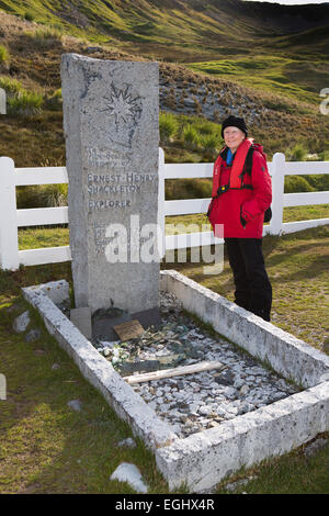 South Georgia, Cumberland Bay, Grytviken, female cruise tourist at Ernest Shackleton’s grave Stock Photo