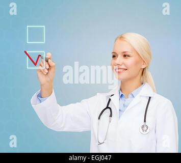 female doctor drawing mark to check box Stock Photo