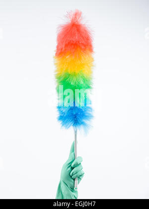 human hand wearing rubber glove holding up feather duster Stock Photo