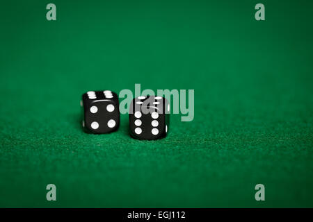 close up of black dice on green casino table Stock Photo