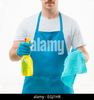 close-up of caucasian male wearing apron, holding cleaning spray bottle and rag on white background Stock Photo
