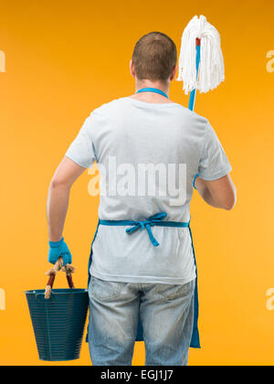 Man removing dirt from glass with squeegee. View of blue sky