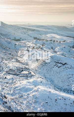 Soft afternoon light on a snowy landscape below Coombes edge above the village of Charlesworth, Derbyshire. Stock Photo