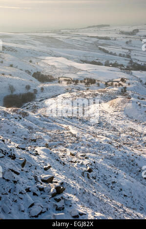Soft afternoon sunlight on a snowy landscape below Coombes edge in Charlesworth, Derbyshire. Stock Photo