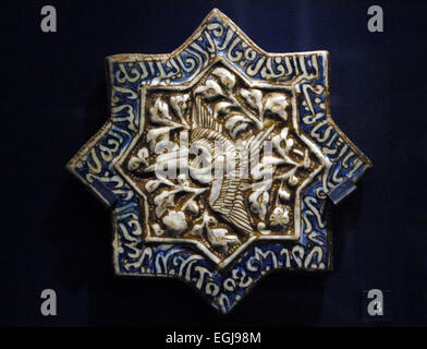 Tile with phoenix and Quranic text. Iran. 1275-1325. Moulded fritware with color i and lustre over glaze. Victoria and Albert Museum. London. England. United Kingdom. Stock Photo