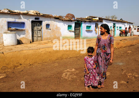 Indian woman and daughter standing outside tribal village houses Kalpi Village Rajasthan India Stock Photo