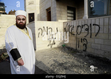 Feb. 25, 2015 - Bethlehem, West Bank, Palestinian Territory - A Palestinian cleric inspects the burnt mosque in the West Bank village of Jab'a, near Bethlehem, just south of Jerusalem, in an apparent attack by Jewish settlers overnight on 25 February 2015. Hate graffiti was spray painted on the building including a Star of David it what authorities believe is a 'price tag ' act of vandalism. The head of Jab'a village council Numan Hamdan said residents detected the fire and were able to put it out before it spread to the rest of the mosque, the Palestinian news agency WAFA reported. Damage was Stock Photo