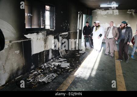 Feb. 25, 2015 - Bethlehem, West Bank, Palestinian Territory - Palestinians inspect the burnt mosque in the West Bank village of Jab'a, near Bethlehem, just south of Jerusalem, in an apparent attack by Jewish settlers overnight on 25 February 2015. Hate graffiti was spray painted on the building including a Star of David it what authorities believe is a 'price tag ' act of vandalism. The head of Jab'a village council Numan Hamdan said residents detected the fire and were able to put it out before it spread to the rest of the mosque, the Palestinian news agency WAFA reported. Damage was caused t Stock Photo