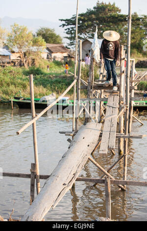 Crossing over waterway,canal at Inle Lake,on a bridge of basic makeshift planks of wood.Burma,Myanmar, Stock Photo