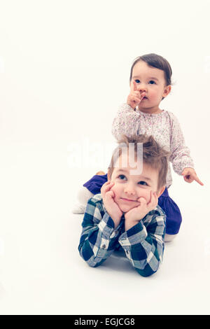 Little toddler girl riding horse on her brother's back Stock Photo