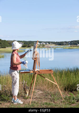 Female artist painting scenic Duck Creek in Wellfleet, Massachusetts. Stock Photo