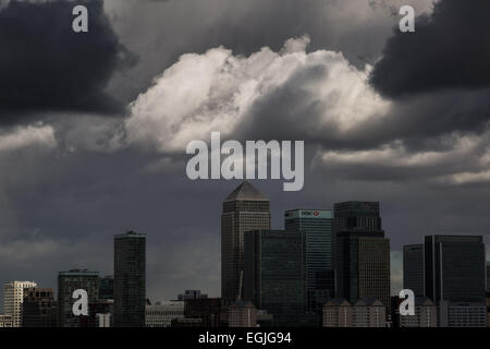 Dark storm clouds over Canary Wharf business park buildings in London Stock Photo