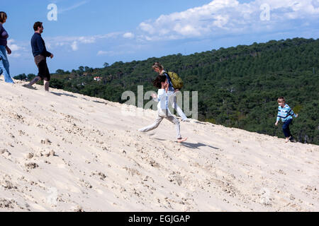 Young girl running down the Dune of Pilat, the tallest sand dune in Europe Stock Photo