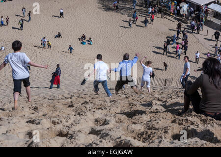 People running down the Dune of Pilat, the tallest sand dune in Europe Stock Photo