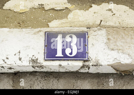 Number thirteen on a wall, detail of a number of information in a house Stock Photo