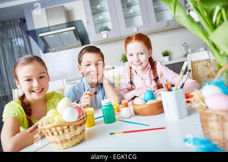 Portrait of happy friends painting eggs in the kitchen Stock Photo