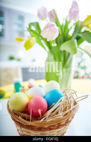 Easter symbols in basket with fresh tulips on background Stock Photo